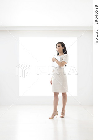 パネルの前でタブレットを持って立つ若い女性 29040539
