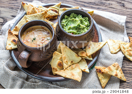 Bowls of guacamole and queso with tortilla chips Bowls of guacamole and queso with tortilla chips 29041848