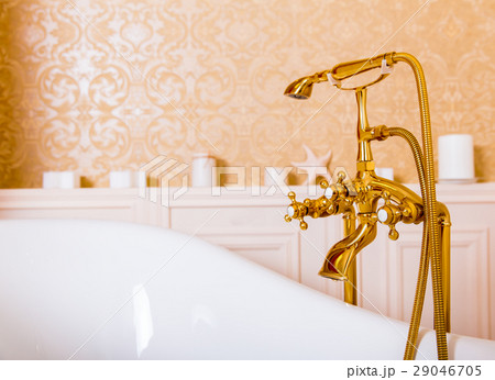 Rich gold faucet and white bath in the bathroom Rich gold faucet and white bath in the bathroom 29046705