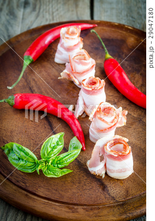 Rolled bacon strips on wooden board Rolled bacon strips on wooden board 29047180