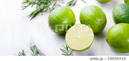 Fresh limes and rosemary on a wooden cutting board 29050419