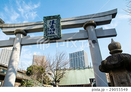 月島の住吉神社入口の鳥居と遠くに見える高層ビルの写真素材