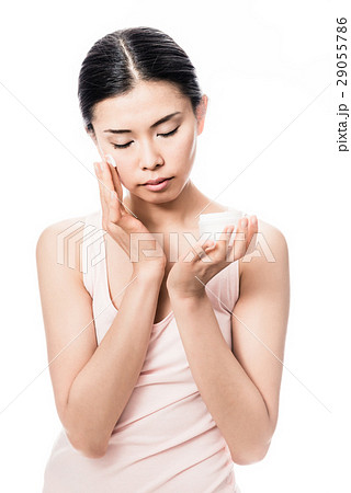 Woman applying facial moisturizer cream  29055786
