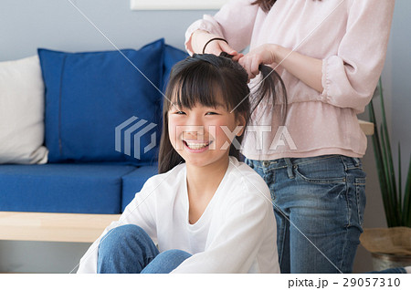 娘の髪を結うママの写真素材