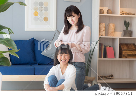 女児の髪を結ぶお母さん 29057311