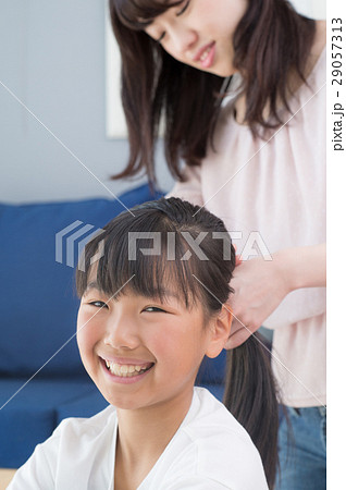 女児の髪を結ぶお母さんの写真素材