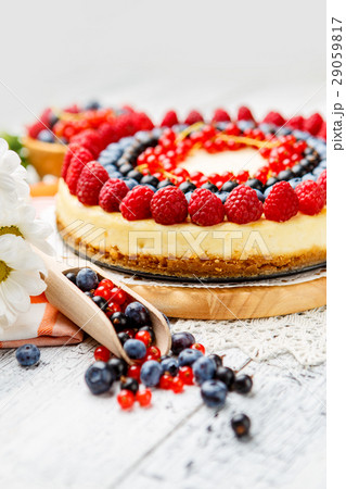 Raspberry and blueberry cheesecake on wooden table 29059817