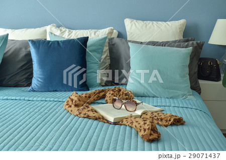 Scarf, book and sunglasses on blue bedding 29071437
