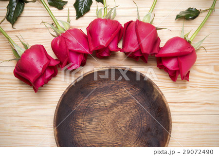 romantic setting with a wood dish and red roses 29072490