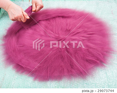 milliner spreads the second layer of wool fibers 29073744