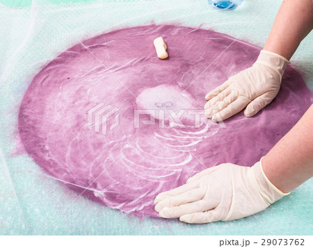 milliner lathers the fibers on back side of layout 29073762