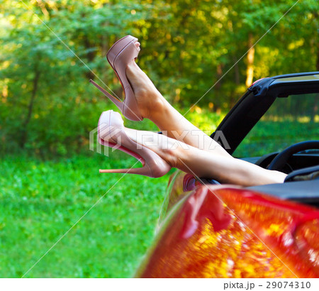 Woman legs in high heels out the windows in car 29074310