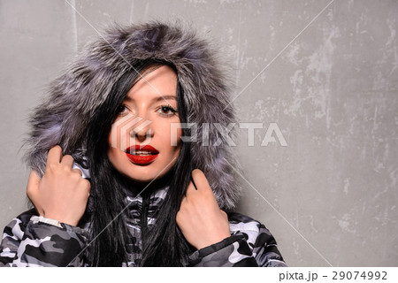young woman in warm winter jacket with fur hood 29074992