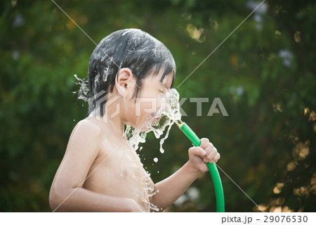 asian boy has fun playing in water 29076530