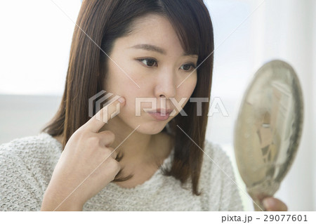 肌の様子をチェックする20代女性 29077601
