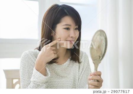 肌の様子をチェックする20代女性 29077617