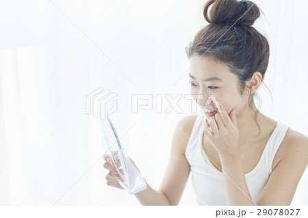 肌の様子をチェックする20代女性 29078027