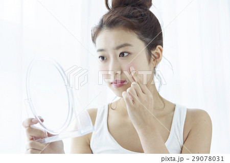 肌の様子をチェックする20代女性 29078031