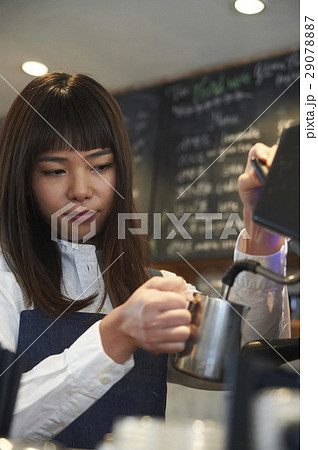 カフェで働く女性 スタッフ エスプレッソマシンの写真素材