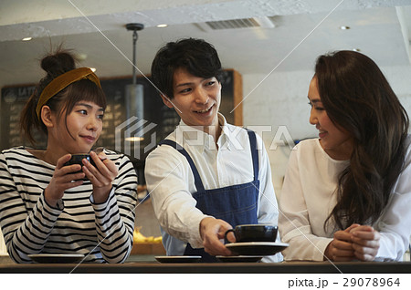 女性にカフェラテを運ぶ男性スタッフ 女性にカフェラテを運ぶ男性スタッフ 29078964