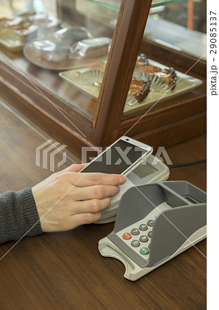 スマホをかざして支払いをする女性手元　キャッシュレス決算 29085137