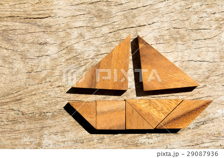 Tangram puzzle in sailing boat on wood background Tangram puzzle in sailing boat on wood background 29087936