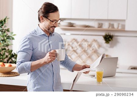 Charismatic freelancer reading newspaper at home 29090234