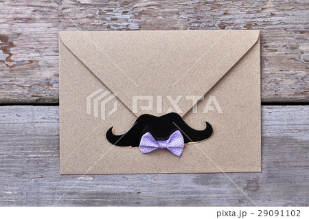 Envelope with mustache on wood. 29091102