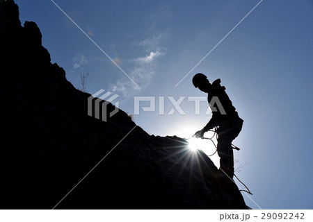 Silhouette of a rock climber hanging on the wall 29092242