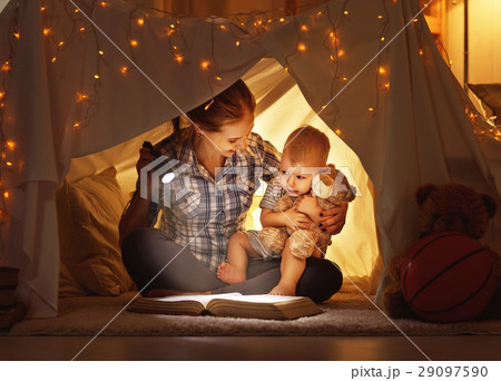 mother and child daughter with a book and a flashlight before go 29097590
