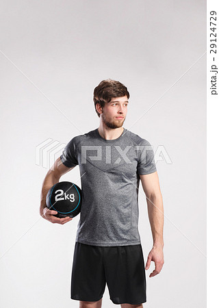 Handsome fitness man holding medicine ball, studio 29124729