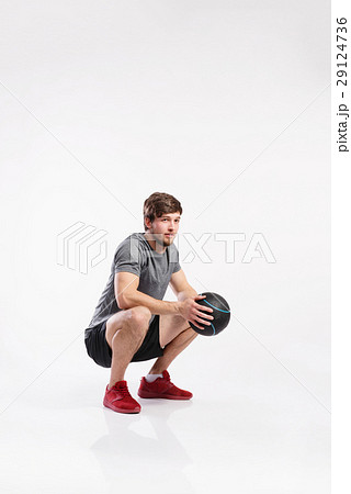 Handsome fitness man holding medicine ball, studio 29124736
