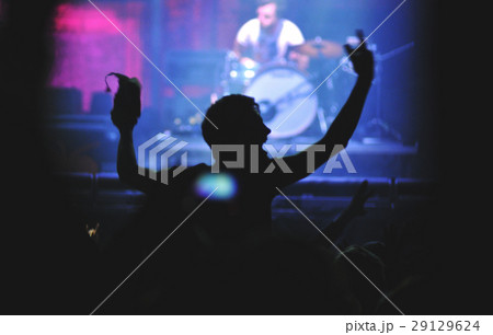 Rear view of man with raised arms enjoying concert Rear view of man with raised arms enjoying concert 29129624