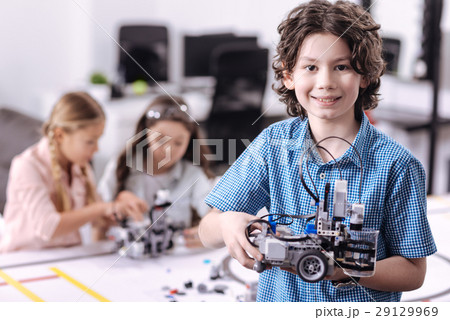 Delighted boy holding robot at school 29129969