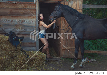 Beautiful woman and a horse on a farm. 29131291