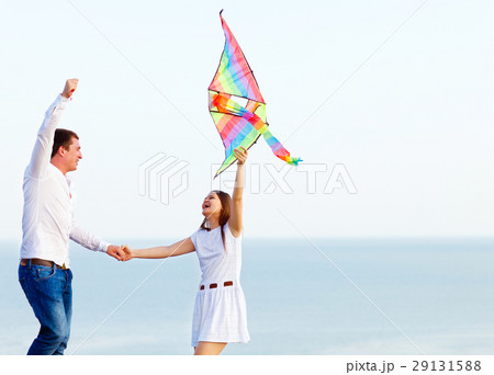 Happy couple in love with flying a kite on beach 29131588