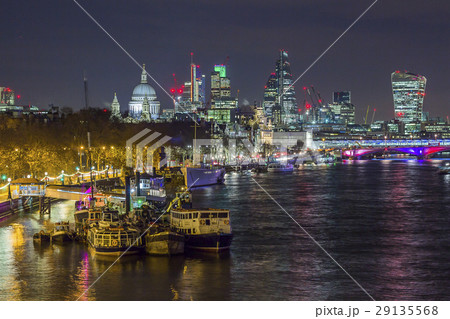 Skyline of London by night alongside Thames river 29135568