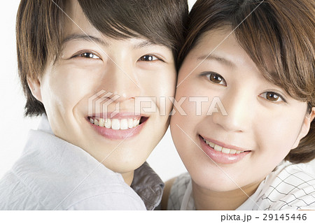 幸せカップル イメージ 笑顔でカメラ目線 頬を寄せ合うの写真素材