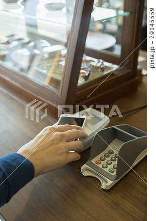 スマホをかざして支払いをする女性手元 29145559