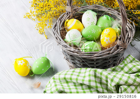 Colorful easter eggs in basket and mimosa Colorful easter eggs in basket and mimosa 29150816