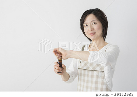 栄養ドリンクをあけるミドル主婦 29152935