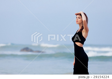 beautiful young woman standing on the sand coast 29154224