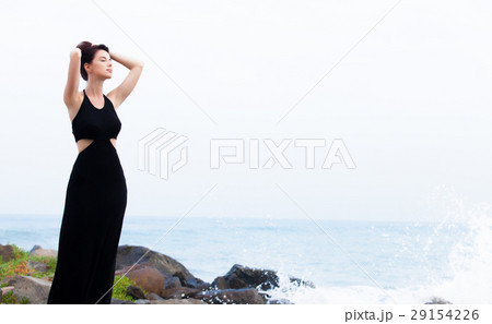 beautiful young woman standing on the stone coast beautiful young woman standing on the stone coast 29154226
