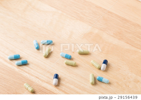 Scattered medicine green and blue capsules 29156439