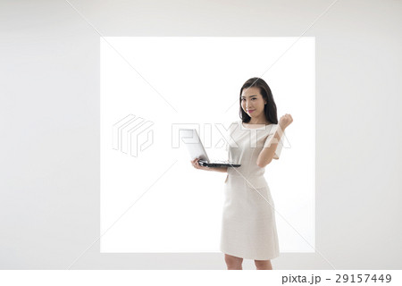 パネルの前でノートパソコンを持ってガッツポーズをする若い女性 パネルの前でノートパソコンを持ってガッツポーズをする若い女性 29157449