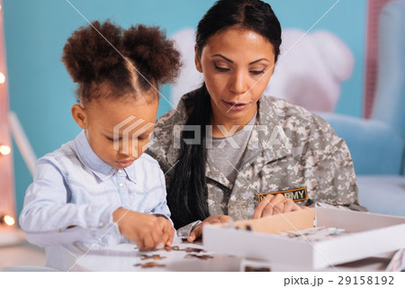 Kind loving mom helping her child with a puzzle Kind loving mom helping her child with a puzzle 29158192