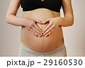 Happy young mother shows heart against belly on last month of pr 29160530