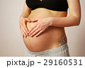 Happy young mother shows heart against belly on last month of pr 29160531