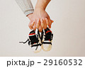 Happy young parents hold in their hands children's shoes of futu 29160532