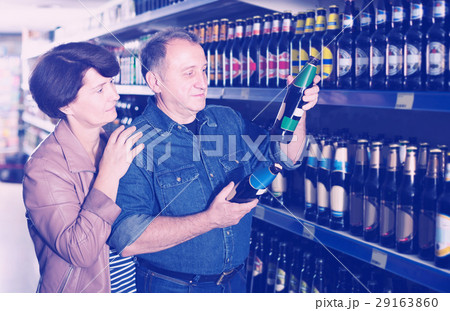 Portrait of an elderly couple buying a beer at the grocery store 29163860